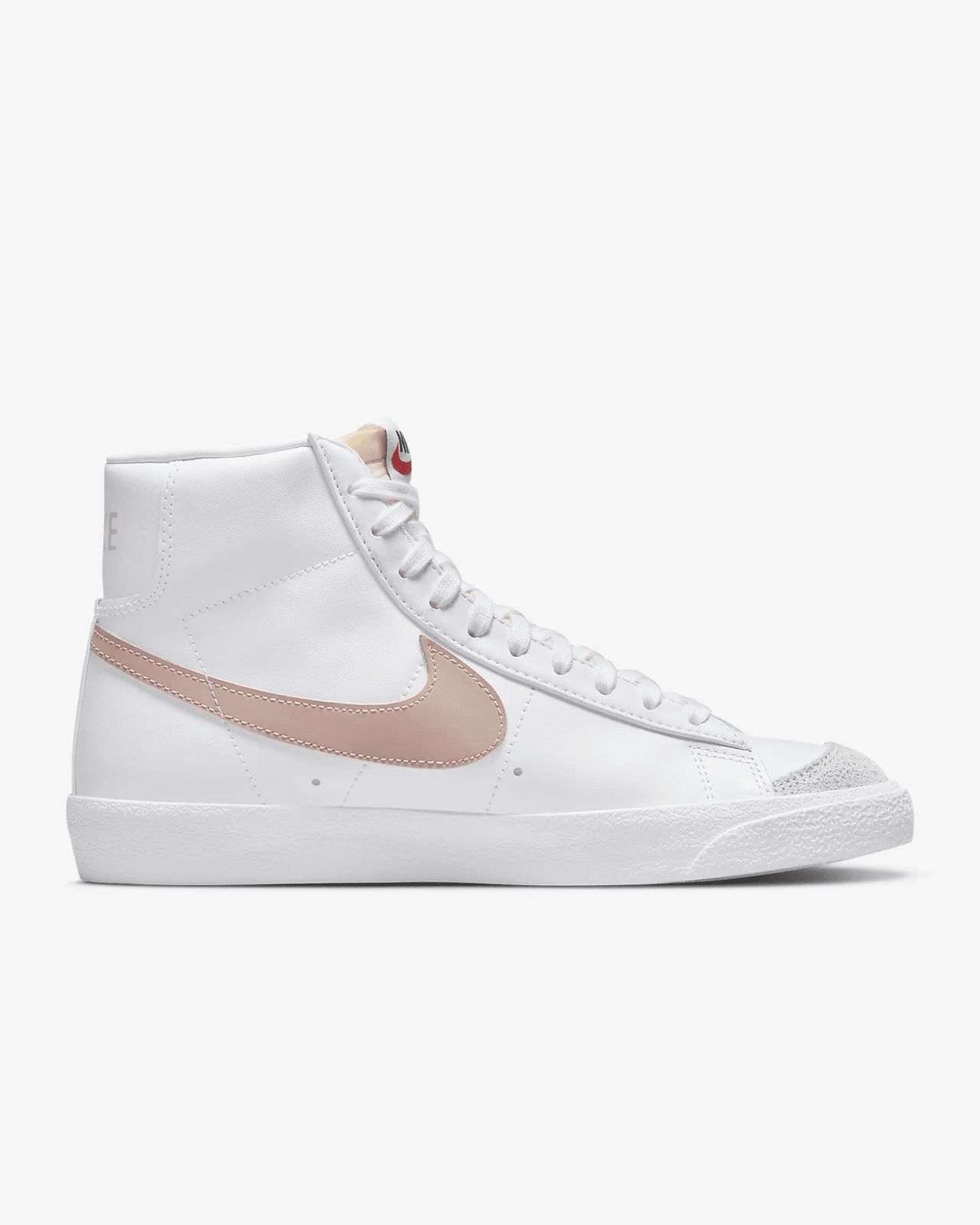 A white Nike Blazer Mid '77 sneaker with pink accents and suede details.