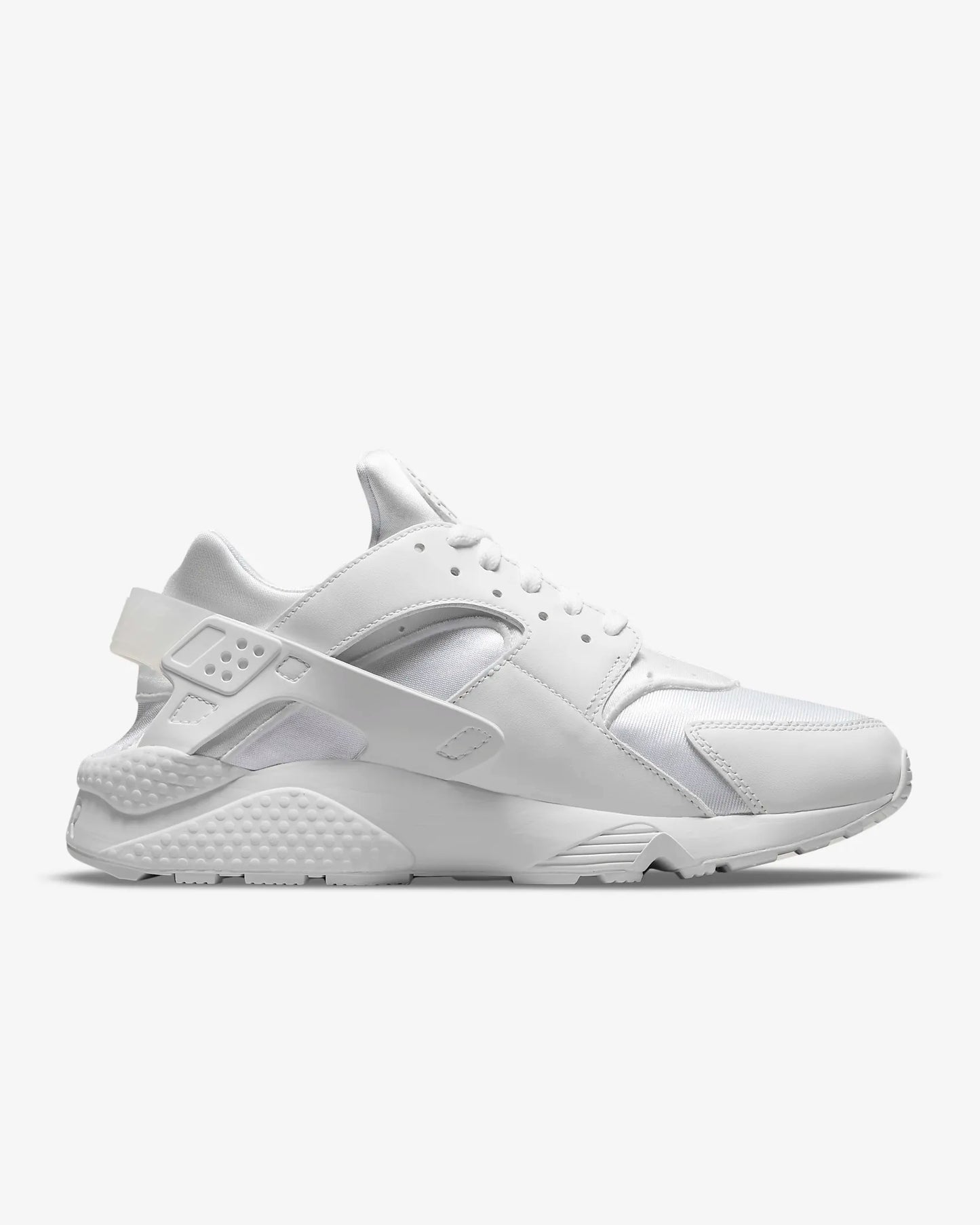 A pair of white Nike Air Huarache sneakers with low-top design and visible sole unit.