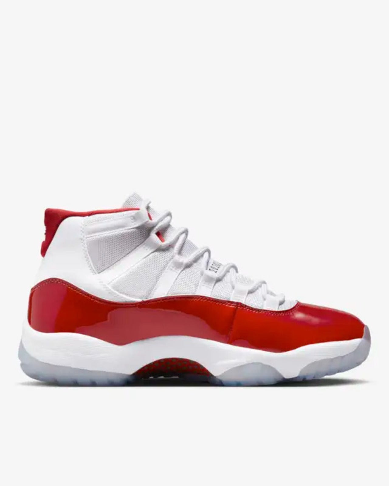 A pair of white Air Jordan 11 Retro basketball shoes with red accents and a high-cut patent leather overlay.